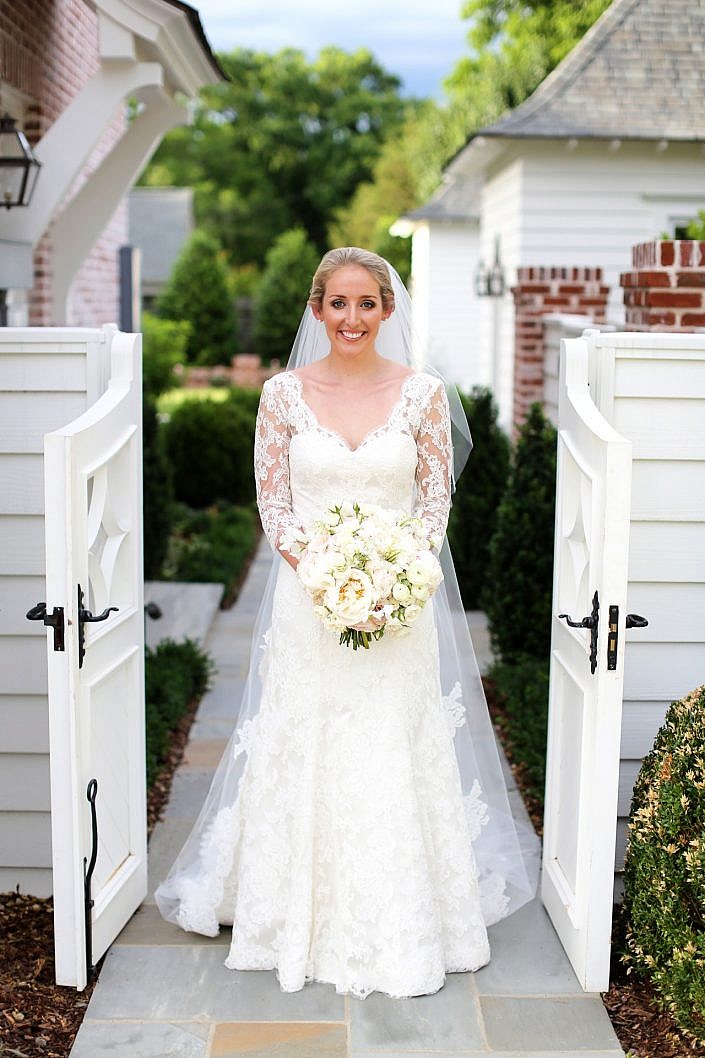 smiling bride standing in garden gate