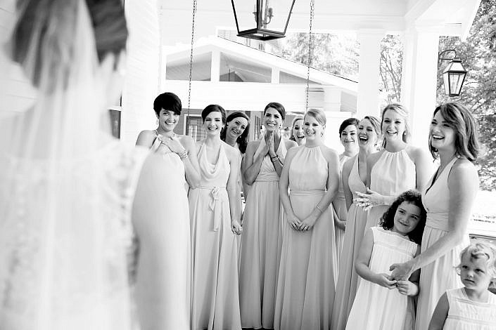 bridesmaids smiling first look with bride
